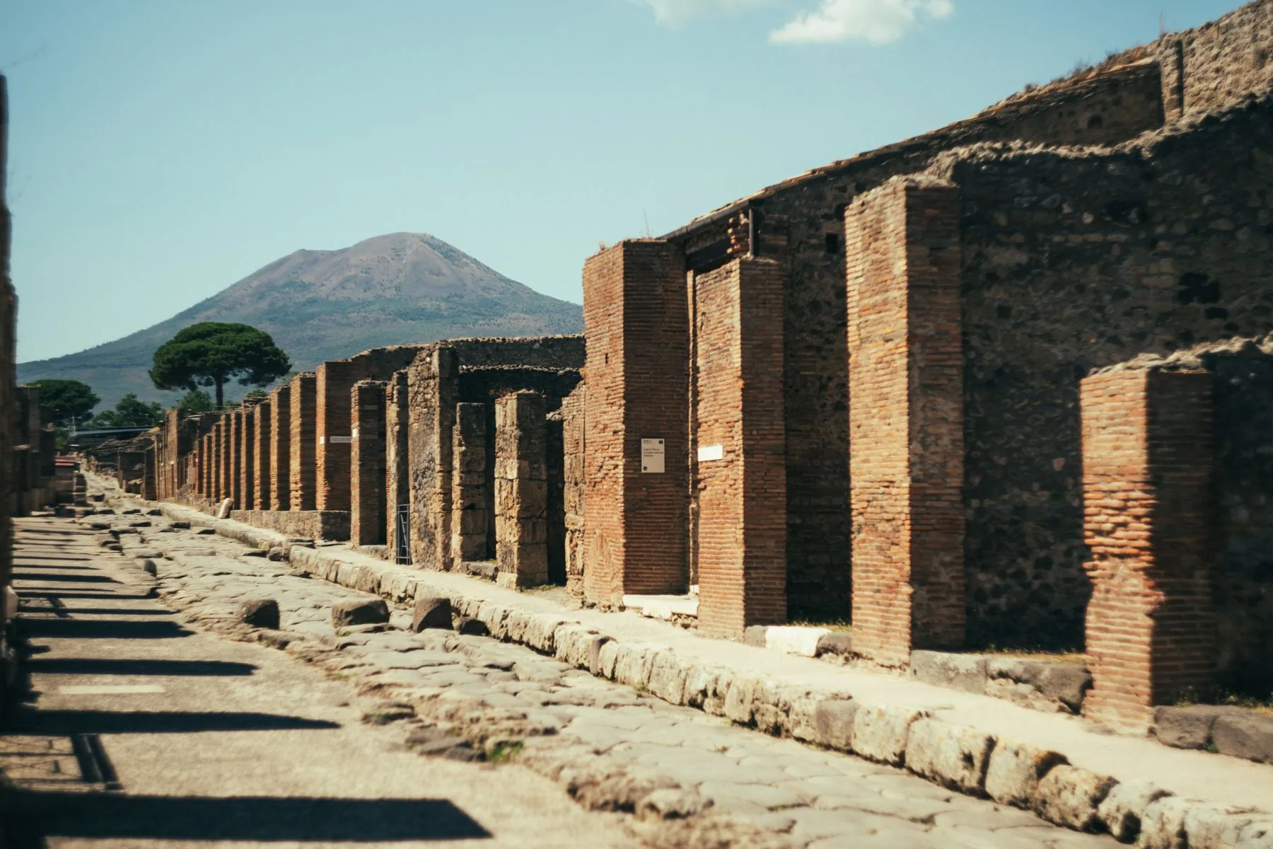 Ancient Pompeii street and ruins with Mount Vesuvius in the distance
