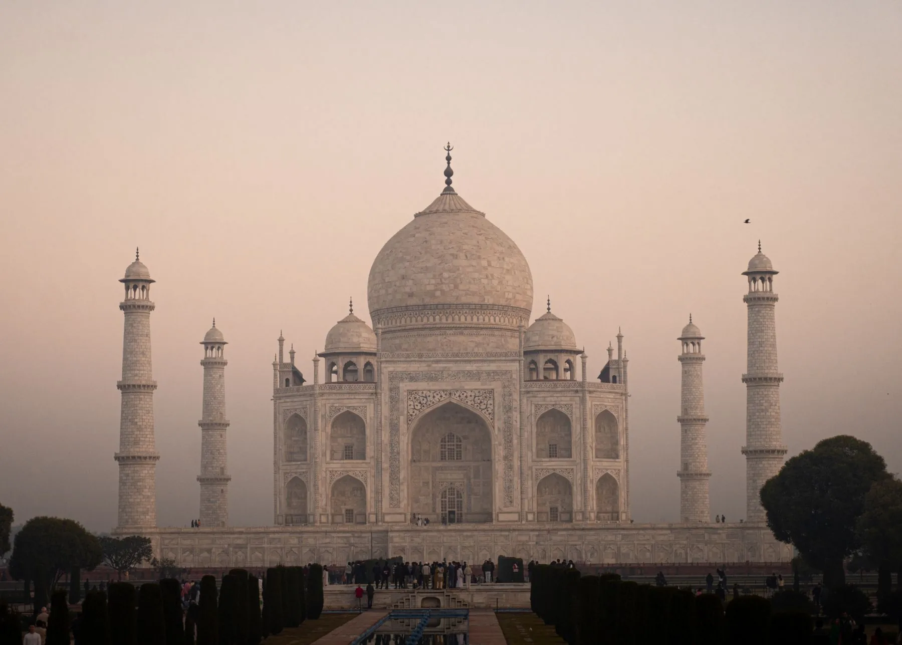 The Taj Mahal's marble dome and minarets in the warm light of Agra